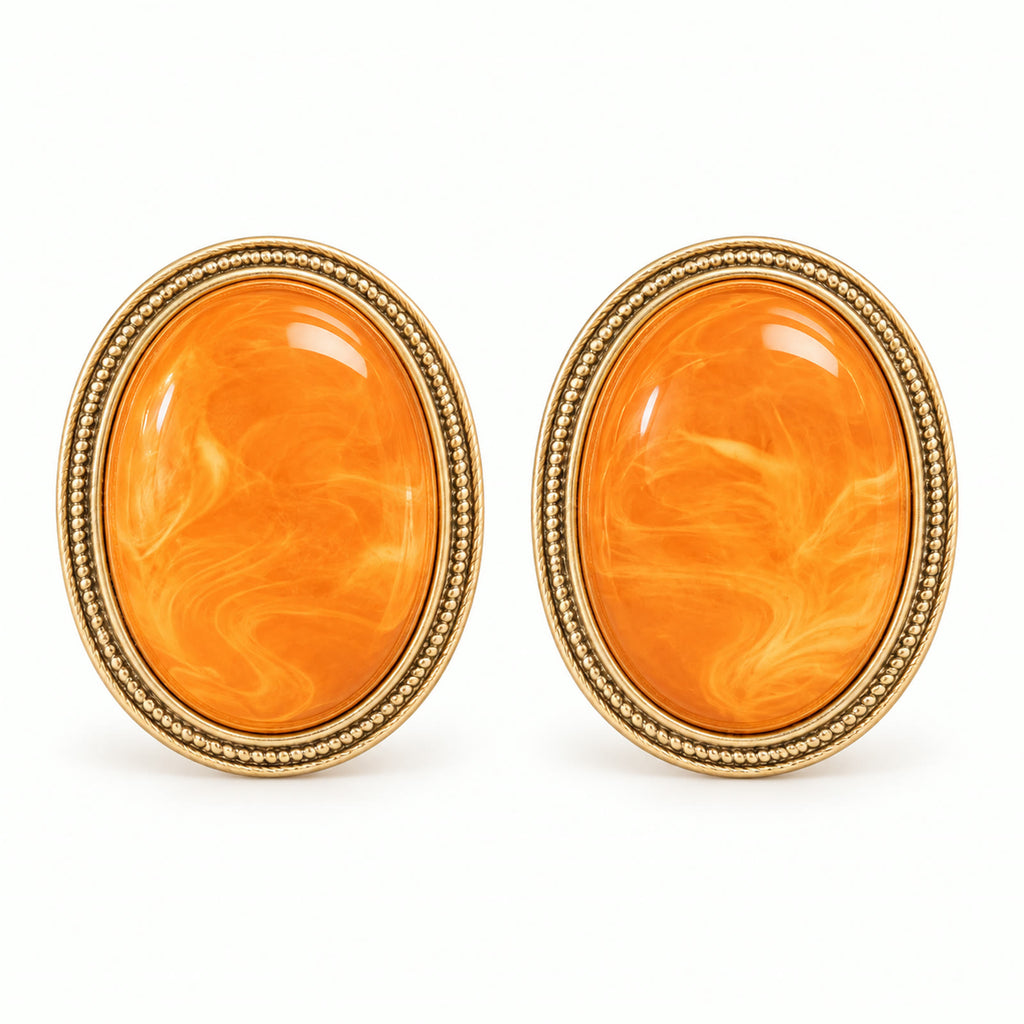 Vintage orange amber gold-plated oval earrings on a white background