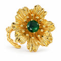 Vintage gold-plated flower ring with a green rhinestone center on a white background.